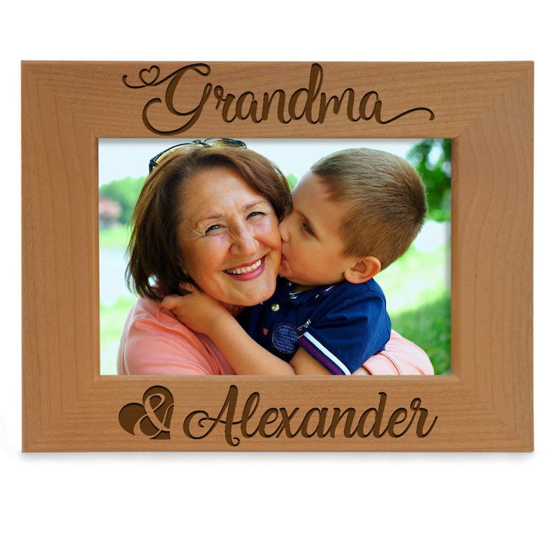 May include: A wooden picture frame with the words "Grandma & Alexander" engraved on it. The frame has a photo of a grandmother and a young boy.