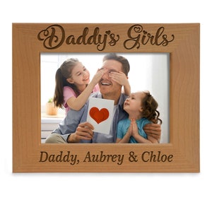May include: A wooden photo frame with the text "Daddy's Girls" at the top and "Daddy, Aubrey & Chloe" at the bottom. The frame has a picture of a father with his two daughters.