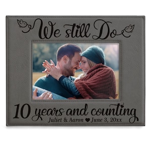 May include: Gray photo frame with a picture of a couple. The frame has the text "We still do" and "10 years and counting" with the names "Juliet & Aaron" and the date "June 3, 20xx".