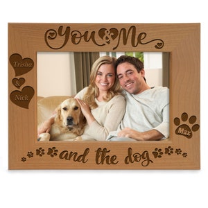 May include: A wooden photo frame with the text "You & Me and the dog" engraved on it. The frame has two hearts with the names "Trisha & Nick" engraved on them and a paw print with the name "Max" engraved on it.