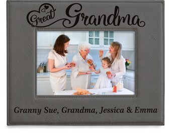 May include: A rectangular gray faux leather picture frame with stitched edges. The top features the text Great Grandma with a heart icon. The bottom is engraved with the text Granny Sue, Grandma, Jessica & Emma. A photo of four people is inside.