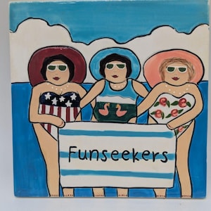 May include: A square ceramic tile featuring a whimsical illustration of three women in swimsuits and sunglasses, holding a striped banner that reads "Funseekers". The background depicts a blue sky and water.