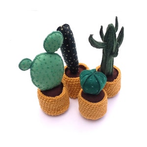 May include: Four felt cactus plants in yellow crocheted pots. The cacti are green and brown with different shapes and textures.