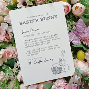 May include: A cream-colored letter from the Easter Bunny, with text and a bunny illustration. The letter is surrounded by pink and yellow flowers, a purple butterfly, and a small Easter bunny figurine.
