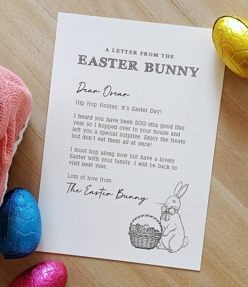 May include: A letter from the Easter Bunny to Oscar, with a drawing of a bunny and a basket of eggs. The letter is on a white paper with a wooden background. There are also chocolate eggs in the image.
