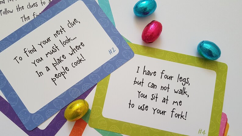 May include: Four colorful cards with handwritten clues for an Easter egg hunt. The cards are decorated with a pattern of blue and white eggs. The text on the cards reads: "To find your next clue, you must look... in a place where people cook!" and "I have four legs, but can not walk, you sit at me to use your fork!"