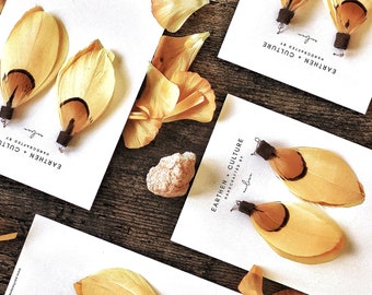 May include: A set of four pairs of feather earrings with a yellow and brown color scheme. The earrings are handmade and feature the text "EARTHEN CULTURE" on the card they are displayed on.