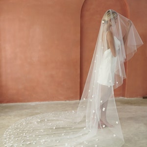 Model wearing petal wedding veil shown from her right side.