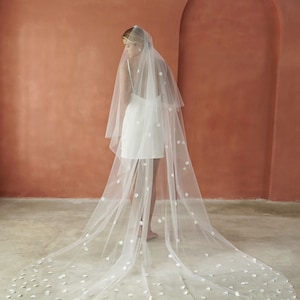 Model wearing wedding veil with circular satin petals shown from the back.