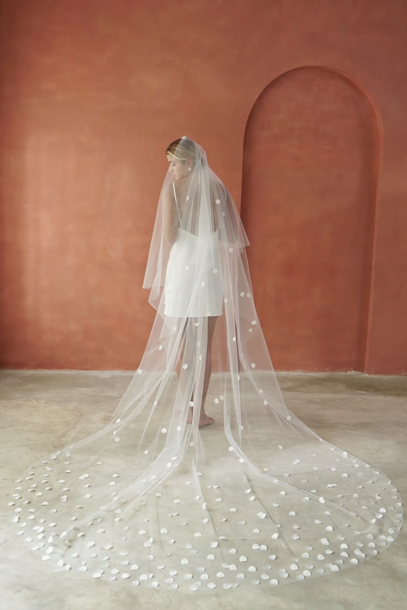 Model wearing wedding veil with circular satin petals shown from the back.