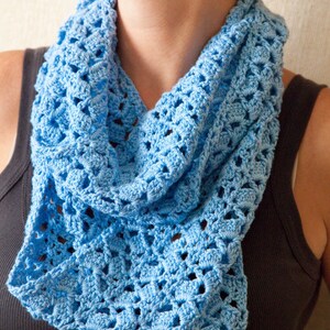May include: A light blue crocheted cowl neck scarf with a lacy pattern. The scarf is worn by a person and the text "PDF Pattern" is visible at the bottom of the image.