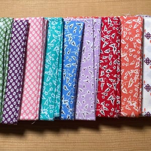 May include: A collection of fabric bundles in various colors and patterns. The fabrics include yellow with white dots, navy with white dots, blue with white dots, green with white dots, purple with white dots, pink with white dots, teal with white stars, and more.