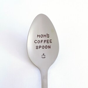 May include: A silver spoon with the words "MOM'S COFFEE SPOON" engraved on it. A small coffee cup icon is also engraved on the spoon.