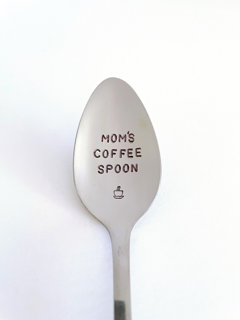 May include: A silver spoon with the words "MOM'S COFFEE SPOON" engraved on it. A small coffee cup icon is also engraved on the spoon.