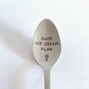 K&ouml;nnte beinhalten: Ein silberner L&ouml;ffel mit dem Text "Dad's Ice Cream Plow" auf der Schale graviert. Unter dem Text ist ein Eiswaffeleis-Symbol graviert.