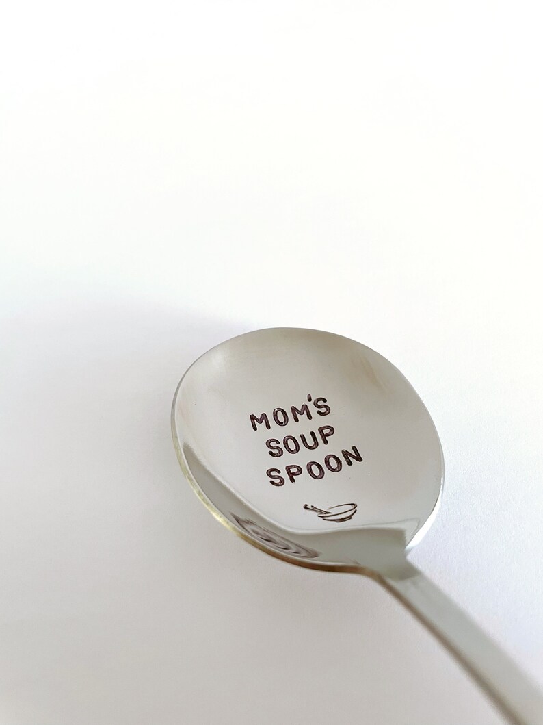 May include: A silver soup spoon with the words "Mom's Soup Spoon" engraved on the bowl. A small illustration of a bowl and spoon is also engraved on the spoon.