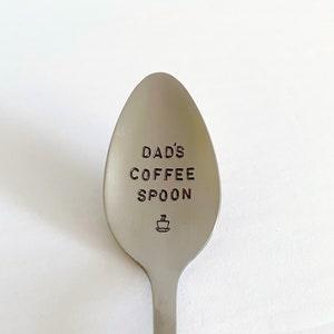 K&ouml;nnte beinhalten: Ein silberner L&ouml;ffel mit der Gravur "DAD'S COFFEE SPOON". Unter dem Text ist ein kleines Kaffeetassen-Symbol graviert.