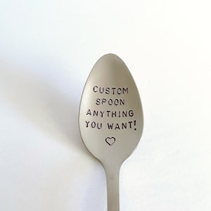 K&ouml;nnte beinhalten: Ein silberner L&ouml;ffel mit der Gravur "CUSTOM SPOON ANYTHING YOU WANT!" Ein kleines Herz ist unter dem Text graviert.