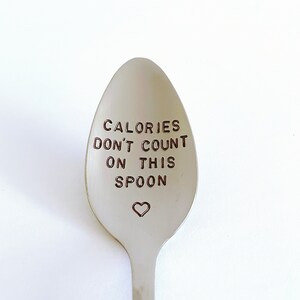 May include: A silver spoon with the text "Calories don't count on this spoon" engraved on the front. A small heart is engraved below the text.