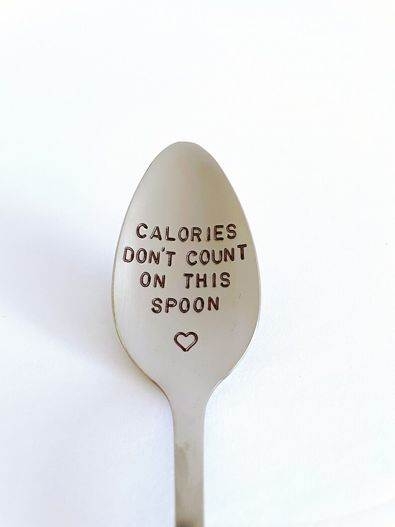 May include: A silver spoon with the text "Calories don't count on this spoon" engraved on the front. A small heart is engraved below the text.