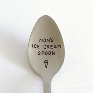 May include: A silver spoon with the text "MOM'S ICE CREAM SPOON" engraved on the front. An ice cream cone icon is engraved below the text.