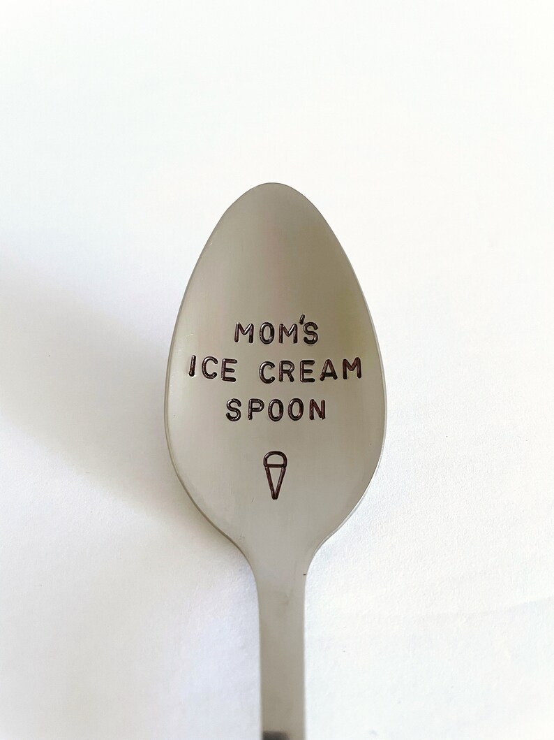 May include: A silver spoon with the text "MOM'S ICE CREAM SPOON" engraved on the front. An ice cream cone icon is engraved below the text.