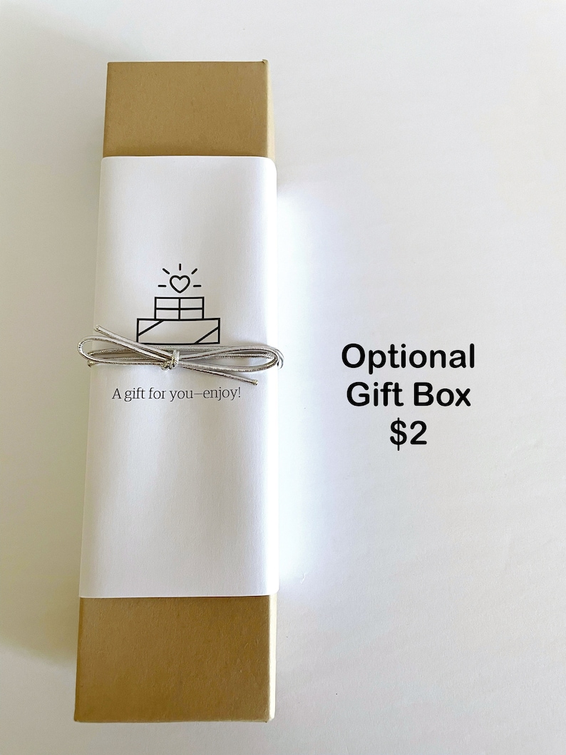 May include: A gold gift box with a white label that says "A gift for you - enjoy!" and has a simple line drawing of a gift box with a heart on top. The text "Optional Gift Box $2" is printed below the box.