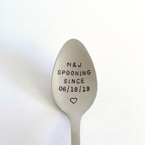 May include: A silver spoon with the text "M&J SPOONING SINCE 06/18/19" engraved on the front. A small heart is engraved below the date.