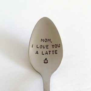 May include: A silver spoon with the words "Mom, I love you a latte" engraved on it. A small coffee cup icon is also engraved on the spoon.