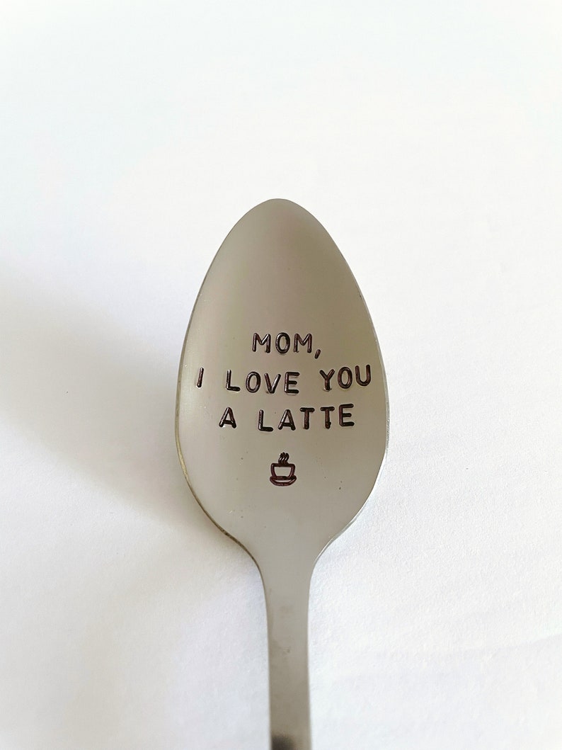 May include: A silver spoon with the words "Mom, I love you a latte" engraved on it. A small coffee cup icon is also engraved on the spoon.