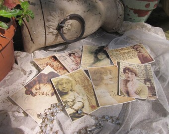 May include: A collection of vintage-style cards featuring women in various poses. The cards are printed on textured paper and have a distressed look. The cards are arranged on a white lace tablecloth.