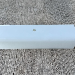 May include: A rectangular, white, semi-translucent light fixture cover with rounded edges. The piece features a smooth, matte finish and a single, small, circular hole centered on the top surface, designed for mounting or ventilation purposes.