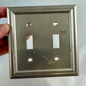 May include: A set of three ceramic mugs with a speckled, matte finish. The mugs are in shades of cream, light gray, and dark gray. Each mug has a simple, minimalist design, perfect for coffee or tea.