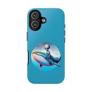 May include: A teal phone case featuring a whimsical design. A gray alien is riding a blue whale, set against a circular background. The whale has colorful accents of pink, blue, and red. The phone case has a dual-camera setup.
