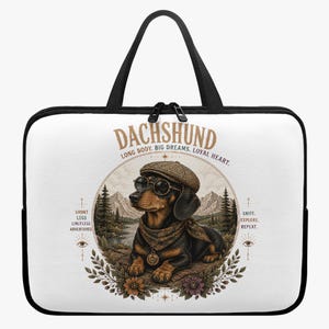 Op de afbeelding: Een witte laptoptas met zwarte randen en handvatten, voorzien van een afbeelding van een teckel met een pet, zonnebril en bandana. De tekst luidt DACHSHUND, LONG BODY. BIG DREAMS. LOYAL HEART., SHORT LEGS LIMITLESS ADVENTURES en SNIFF. EXPLORE. REPEAT.