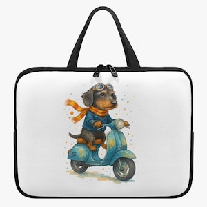 Op de afbeelding: Een witte laptoptas met zwarte rand en handvatten. De tas heeft een aquarel illustratie van een teckel die op een blauwe scooter rijdt, met een bril en een sjaal. De hond is de centrale focus van het ontwerp.
