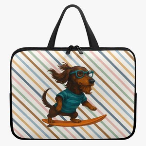 Op de afbeelding: Een laptoptas met een cartoon teckel met een blauwe bril en een gestreept shirt, surfend op een houten surfboard. De achtergrond heeft een patroon van diagonale strepen in verschillende kleuren. De tas heeft een zwarte rits en handvatten.