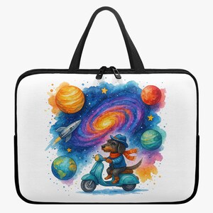Op de afbeelding: Witte laptoptas met een kleurrijke aquarel illustratie van een teckel op een scooter in de ruimte. Het ontwerp bevat planeten, een raket en een melkwegachtergrond. De tas heeft een zwarte rits en handvatten.