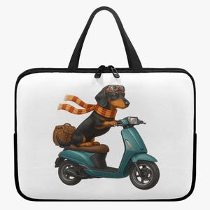 Op de afbeelding: Laptoptas met een teckel die op een turquoise scooter rijdt. De hond draagt een bril en een sjaal met oranje en gele strepen. Achter de hond staat een bruine rieten mand.
