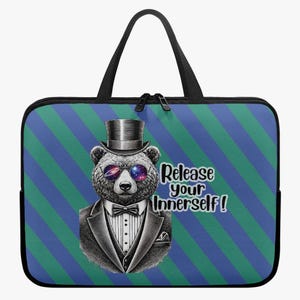 May include: A black laptop sleeve with a handle and zipper closure. The front features a bear wearing a top hat, sunglasses with a galaxy design, and a tuxedo. Text reads "Release your Innerself!" on a blue and green striped background.