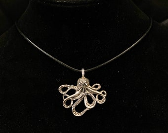 Op de afbeelding: Een zilveren octopus hangerketting aan een zwart koord.