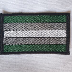 May include: A green, gray, and white striped fabric patch with a black border.
