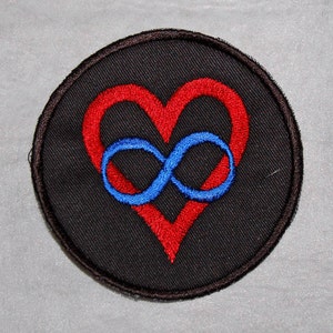 Könnte beinhalten: Ein schwarzer gestickter Aufnäher mit einem roten Herzen und einem blauen Unendlichkeitszeichen im Herzen.