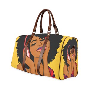 May include: A yellow duffel bag featuring an illustration of a woman with closed eyes wearing pink headphones. The bag has brown leather handles and accents. The woman has dark skin, black hair, and purple lipstick.