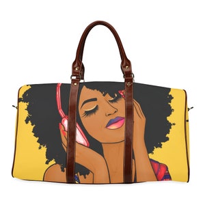 May include: A duffel bag featuring a vibrant illustration of a woman with closed eyes wearing pink headphones. The bag has a yellow background, black hair, and brown leather handles. The woman's lips are a gradient of pink and purple.