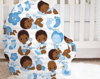 May include: A white baby carrier cover with a blue and white pattern. The pattern features a repeated design of a baby boy with brown skin, blue eyes, and a blue onesie. The baby is holding a blue pacifier and a blue toy. The pattern also includes blue socks, a blue flower, a blue ball, and a blue duck. The text "Kyrie" is repeated throughout the pattern.