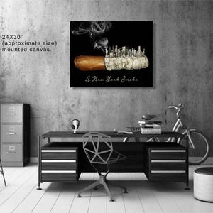 May include: A black and white canvas print of a cigar with a cityscape made of smoke rising from it. The text "A New York Smoke" is printed below the image. The canvas is 24 inches by 30 inches.