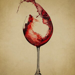 May include: A glass of red wine with a splash of wine coming out of the glass.