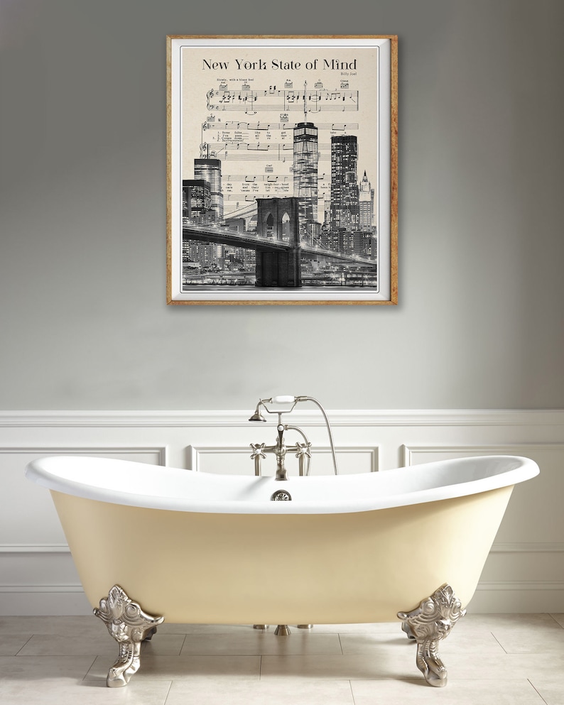 May include: A framed print of a black and white photograph of the New York City skyline with the Brooklyn Bridge in the foreground. The image is superimposed on a sheet of music with the title "New York State of Mind" by Billy Joel.