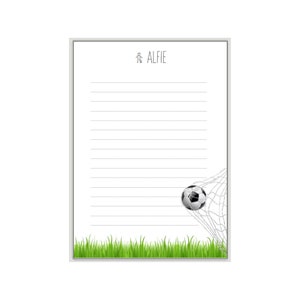 K&ouml;nnte beinhalten: Ein wei&szlig;er Notizblock mit einem grauen Rahmen und einem Fu&szlig;ball, der ins Netz geht. Der Notizblock tr&auml;gt den Namen "Alfie".